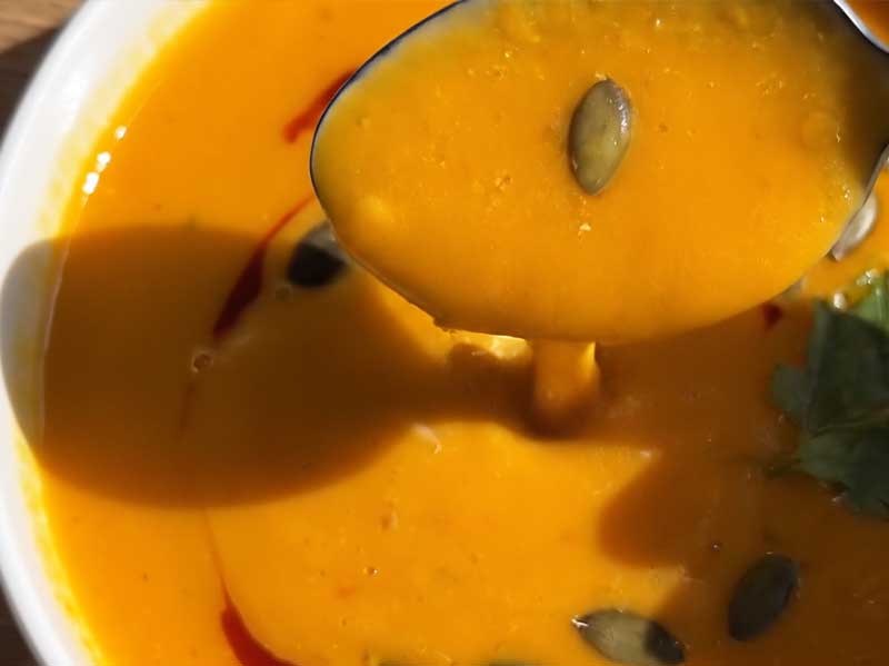 MiNa´s Kürbiscremesuppe mit Löffel und Kürbiskernen